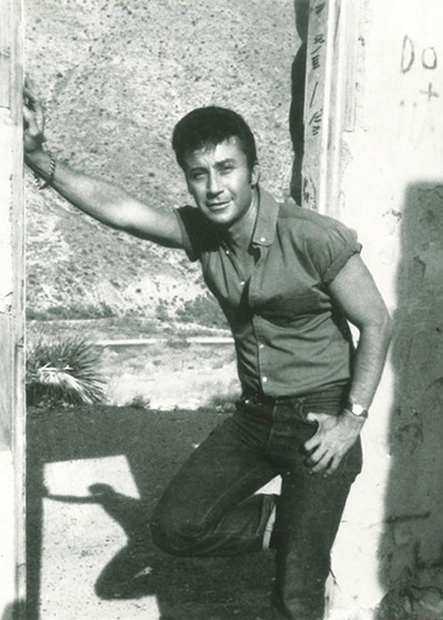 john rechy posing in a doorway